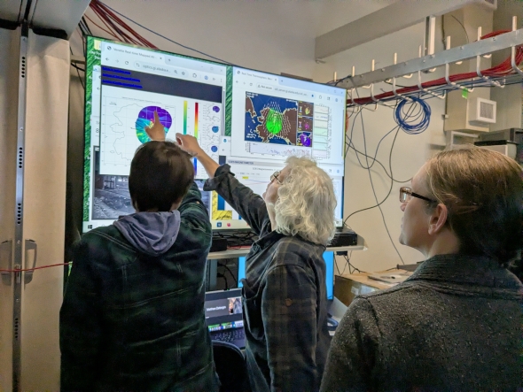 Meghan Burleigh and Leslie Lamarsh at a screen with Kristina begin to analyse initial flight data.